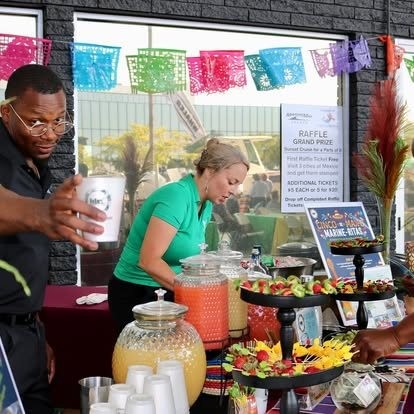 Tony and Mariel actively preparing drinks at a themed bar